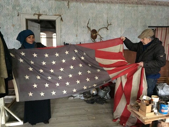 Rahma och Oan håller upp Anna Tappans amerikanska flagga på Sjundby yttre vinden